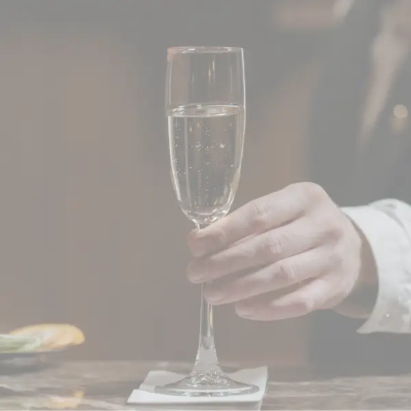 Bartender serving a glass of prosecco in an elegant setting, representing the exceptional services of Design Your Italy.